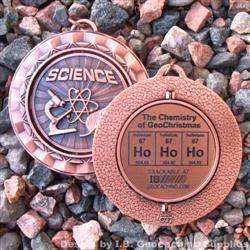 Ho Ho Ho - The Chemistry of GeoChristmas - Antique Bronze Spinning Geomedal Geocoin